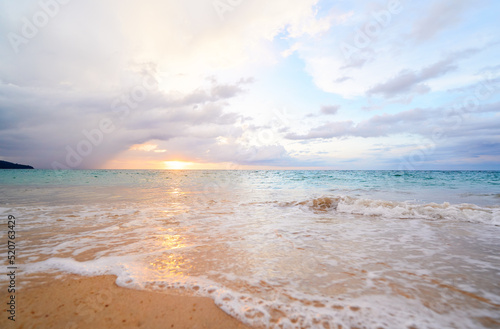 Seascape with sunset on the ocean shore. Beautiful cloudy sky.