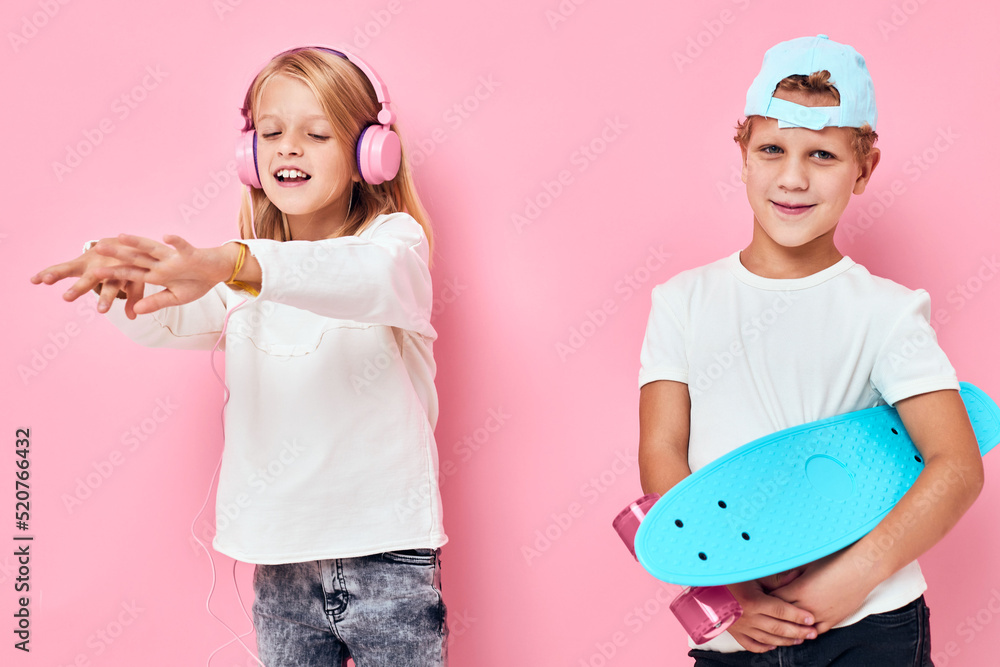 a boy in a cap and a girl smiling and listening to music in headphones isolated background