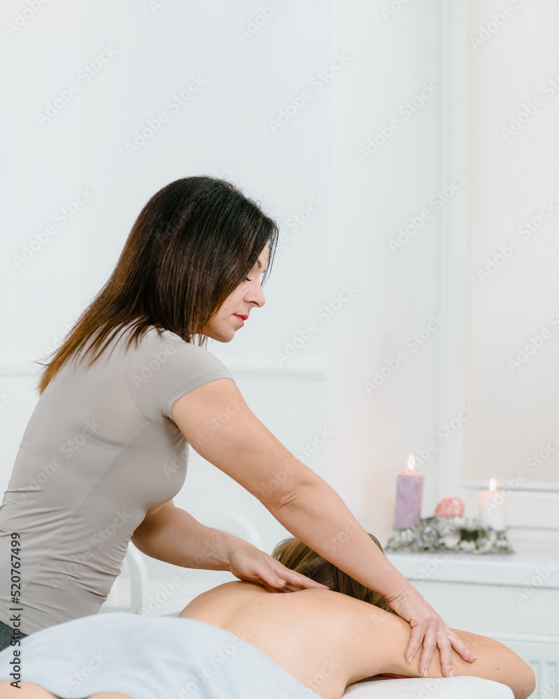 Female masseur doing back massage for woman in beauty salon Female masseur doing back massage for woman in beauty salon