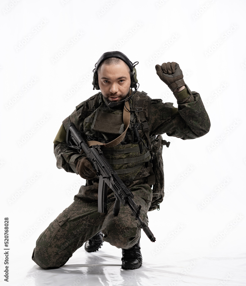 Fototapeta premium soldier in the studio on a white background. a man in military uniform with a rifle or machine gun. military or airball player