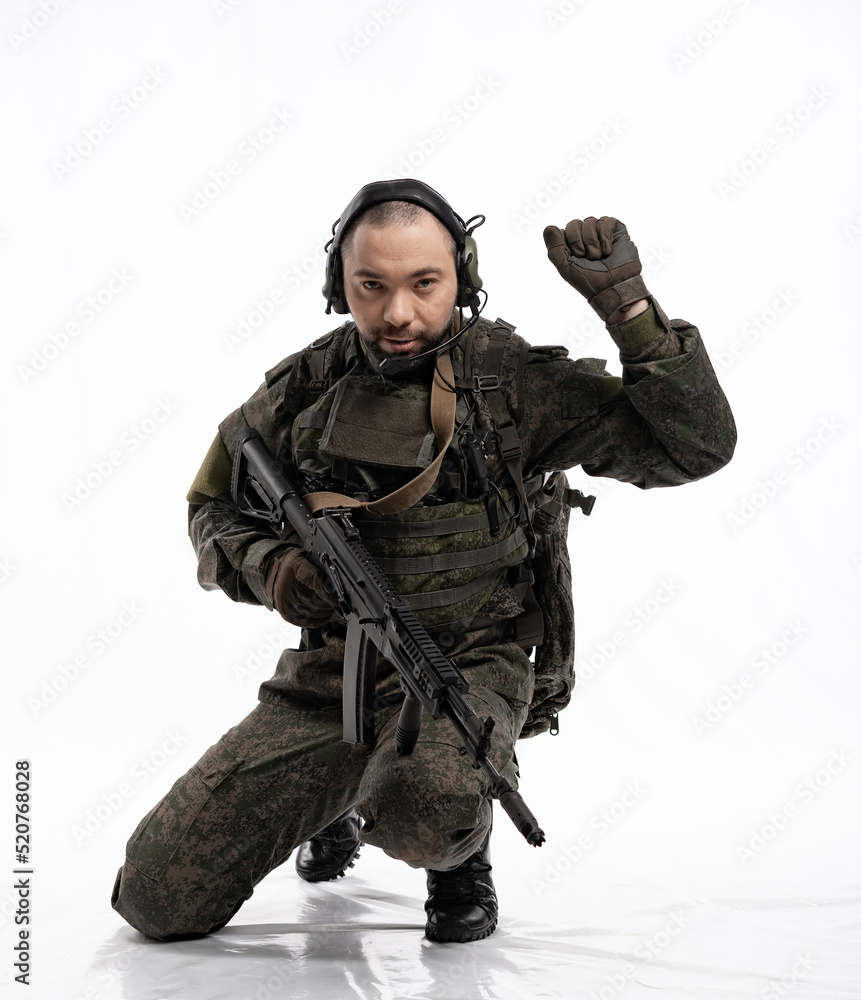 soldier in the studio on a white background. a man in military uniform with a rifle or machine gun. military or airball player