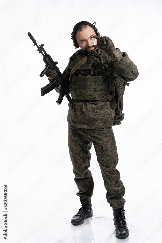 soldier in the studio on a white background. a man in military uniform with a rifle or machine gun. military or airball player soldier in the studio on a white background. a man in military uniform with a rifle or machine gun. military or airball player