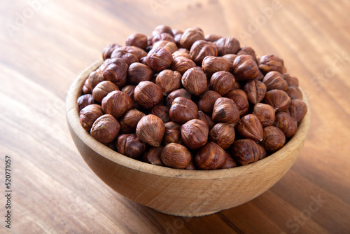 Bowl full of hazelnuts on wooden background 