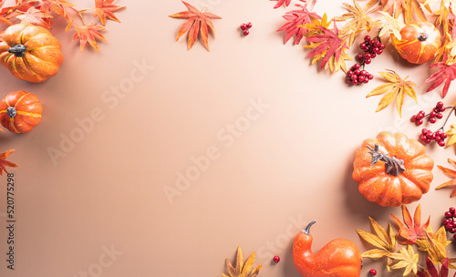 Autumn and thanksgiving decoration concept made from autumn leaves  berry and pumpkin on dark background. Flat lay  top view with copy space.