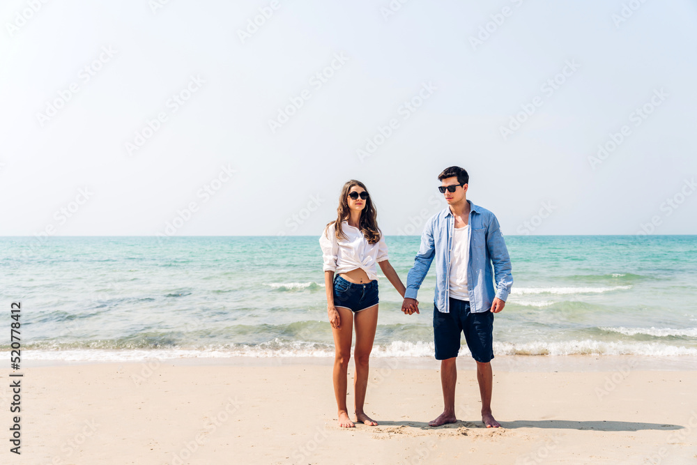 Vacation romantic love young happy smile couple in honeymoon travel holiday trip standing on sand at blue sky sea beach having fun and relaxing together on tropical beach.Summer travel Vacation romantic love young happy smile couple in honeymoon travel holiday trip standing on sand at blue sky sea beach having fun and relaxing together on tropical beach.Summer travel