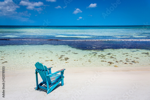 Idyllic beach with rustic adirondack chair in Aruba, Dutch Antilles photo