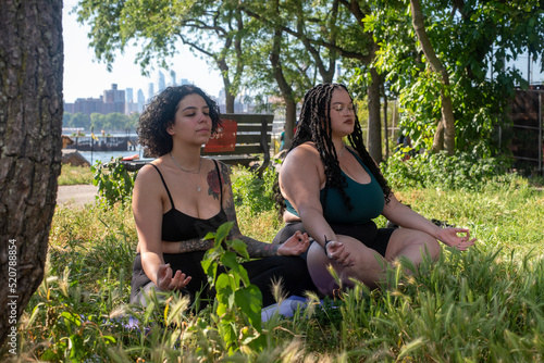 Two women meditating in park