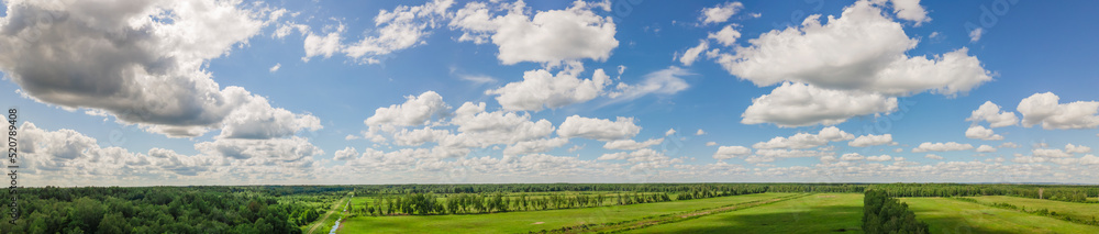 Blue sky panorama with clouds over tops of green trees. Blue sky and white cloud soft. White clouds background.
