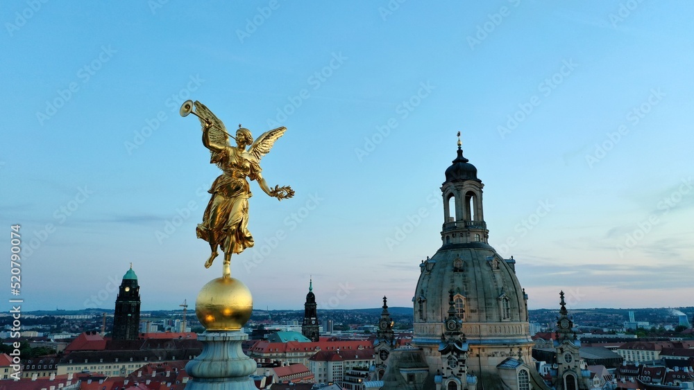 Golden sculpture of an angel on top of the Kunsthalle im Lipsiusbau. Sunset in Dresden, Germany.