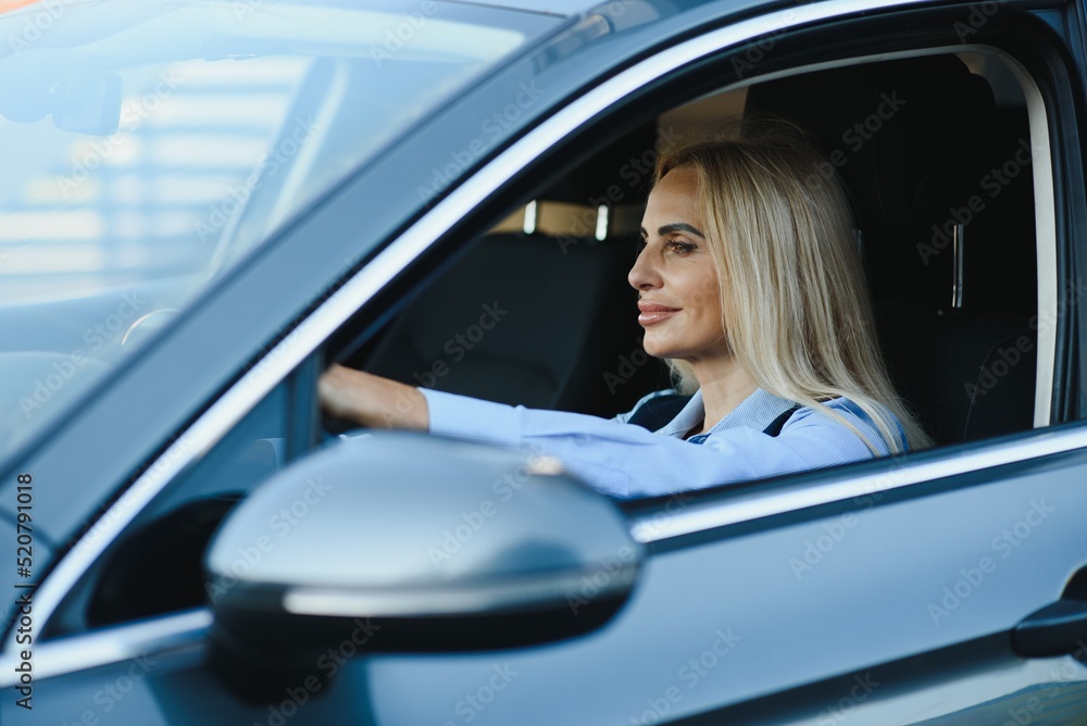 Businesswoman sitting in drivers seat in her car