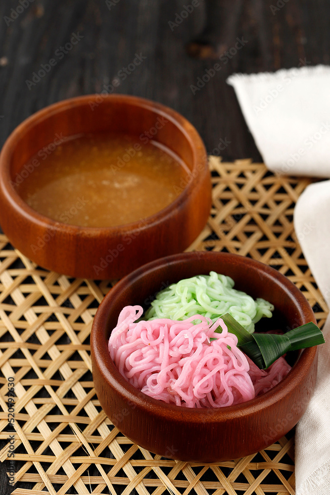 Putu Mayang or Petulo, Indonesian Traditional Javanese Snack Made of Rice Flour Strands Curled up into a Ball with Food Coloring, Served with Coconut Milk and Palm Sugar Syrup. Putu Mayang or Petulo, Indonesian Traditional Javanese Snack Made of Rice Flour Strands Curled up into a Ball with Food Coloring, Served with Coconut Milk and Palm Sugar Syrup.