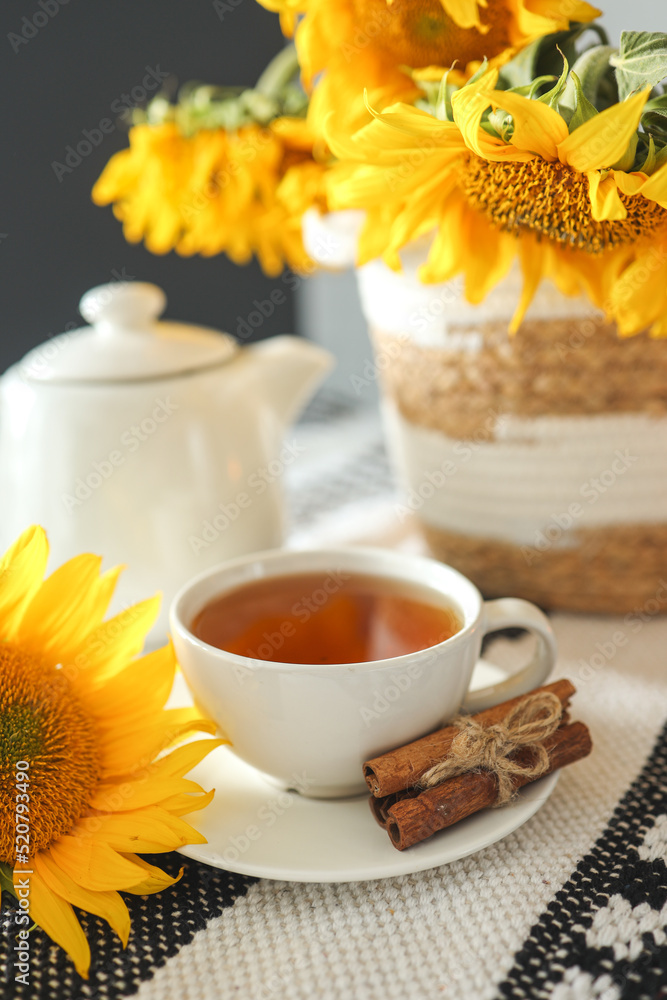 A cup of tea and a teapot with a candle on a table with sunflowers, tea time, aesthetics A cup of tea and a teapot with a candle on a table with sunflowers, tea time, aesthetics