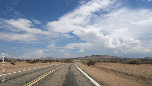 Wallpaper Mural Point of view driving on a Mojave Desert highway in Apple Valley, California with blue sky and puffy clouds Torontodigital.ca