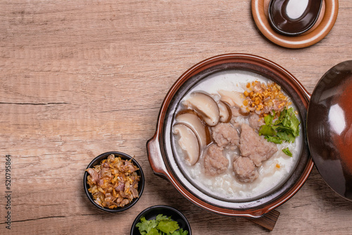 Pork porridge with shiitake mushrooms in brown cups topped with coriander and fried garlic