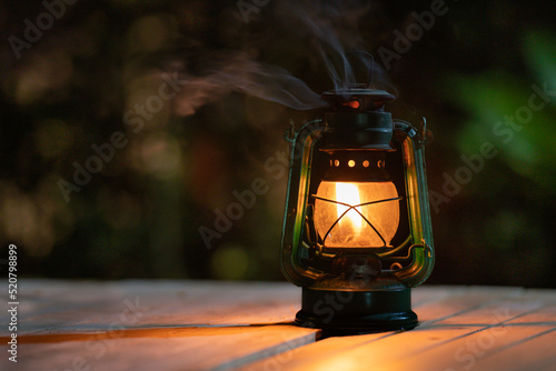 antique kerosene lamp with lights on the wooden floor at night