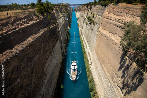 Boat in the canal of Corinth. A sailboat crosses the Corinth Canal in the Peloponnese. Greece, July 2022.