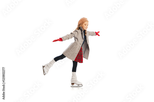 Portrait of stylish little girl, child posing, skating isolated over white studio background