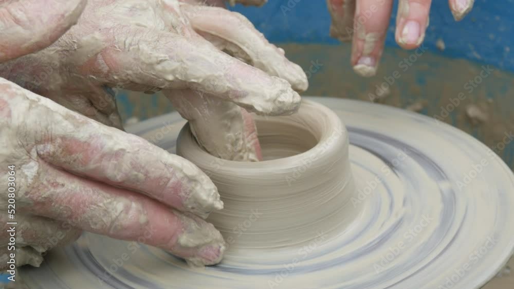 Clay modeling master class. Teacher show children hands clay pot. Potter male hands shape and sculpt the soft white clay pot, spinning on potter wheel in creative workshop. Shape of pottery close up Clay modeling master class. Teacher show children hands clay pot. Potter male hands shape and sculpt the soft white clay pot, spinning on potter wheel in creative workshop. Shape of pottery close up
