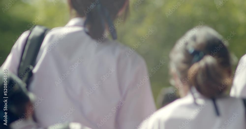 Slow motion back view of the Asian high school students in white uniform are going back to school when school starts. Slow motion back view of the Asian high school students in white uniform are going back to school when school starts.