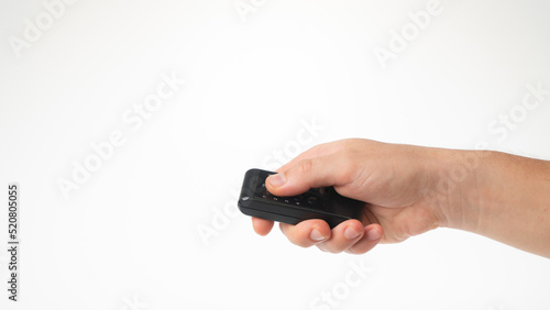 Fotografía A man's hand holds a small remote control on a white background