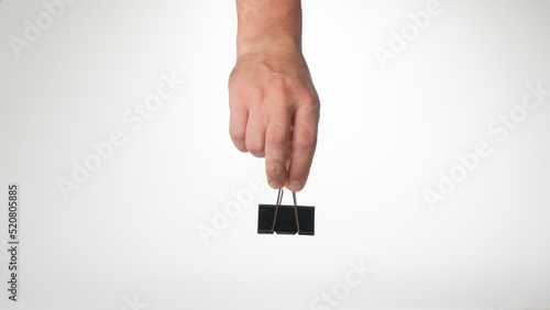 Fotografía A man's hand on top holds a clip to clip paper space for text