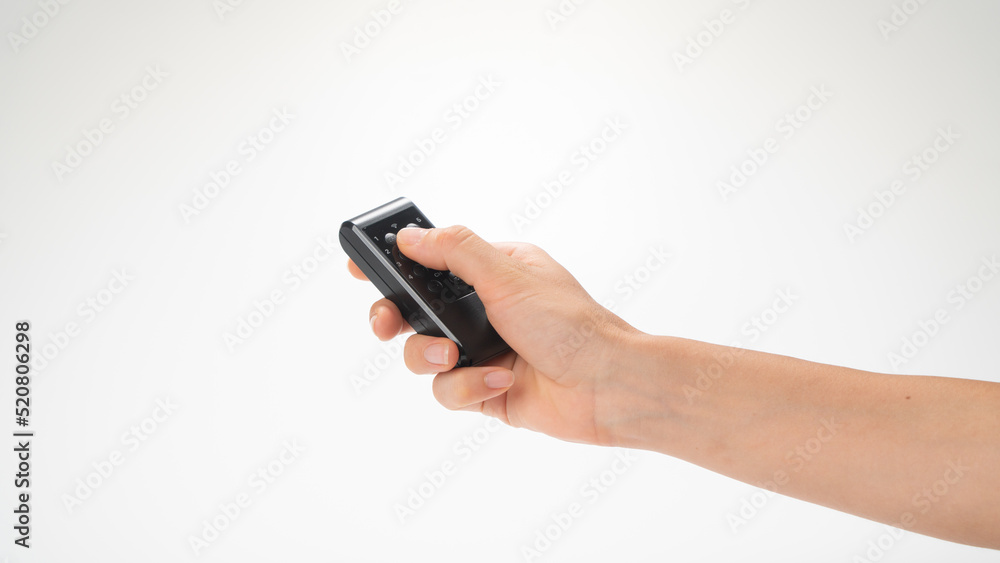Female hand with remote control pointed upwards on a white background Female hand with remote control pointed upwards on a white background