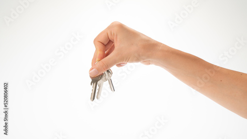 A woman's hand holds a bunch of keys on a white background