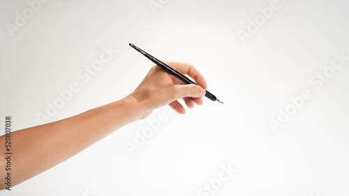 A woman's left hand holds a pen for calligraphy gesture writes