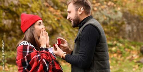 Young man proposing to his ...