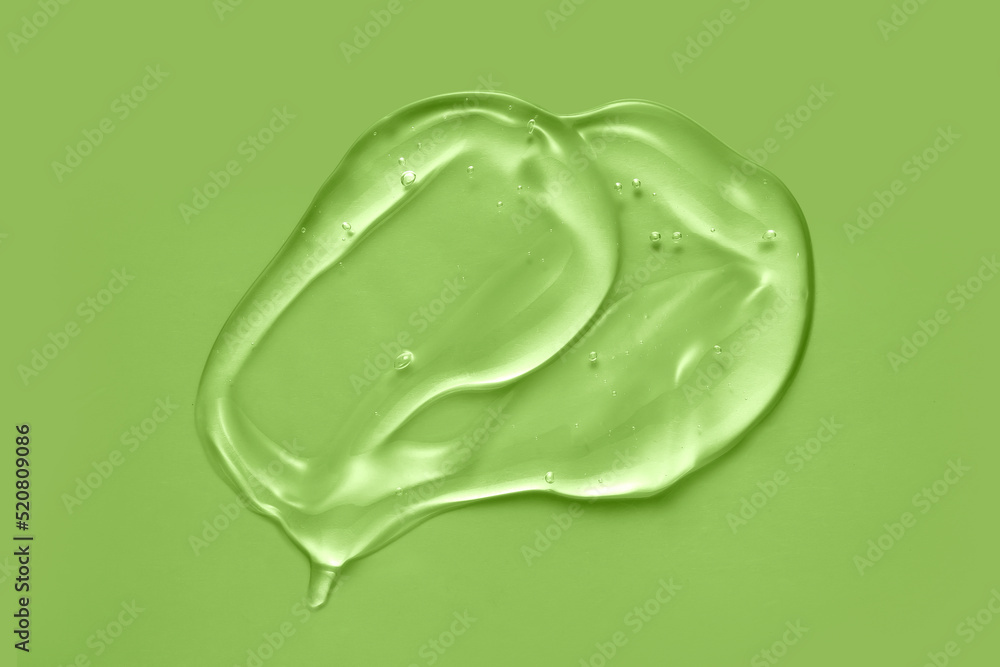 Cosmetic serum gel beauty swatch smear smudge on green color background. Skincare beauty product with bubbles texture. Cosmetic serum gel beauty swatch smear smudge on green color background. Skincare beauty product with bubbles texture.