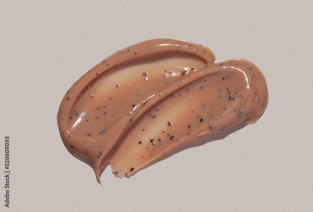 Scrub cream swatch smear smudge on brown color background. Scrub cream swatch smear smudge on brown color background.