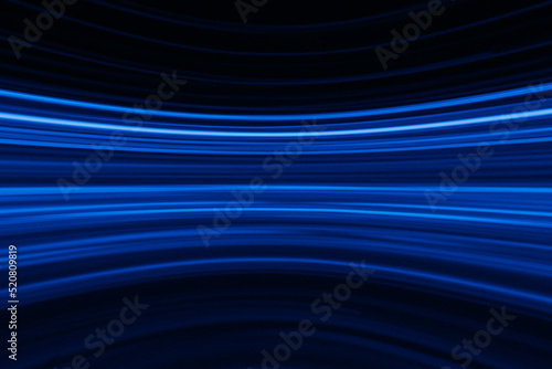 Blur glowing lines. Neon abstract background. Futuristic radiance. Defocused luminous navy blue color curve streak light flare motion on dark black.