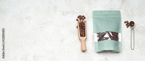 Coffee bag, scoop and spoon on light background with space for text