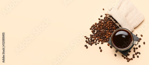 Cup of hot coffee and beans on beige background with space for text, top view