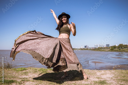 happy young Latin woman on vacation in Argentina, walking along the Vicente Lopez waterfront photo