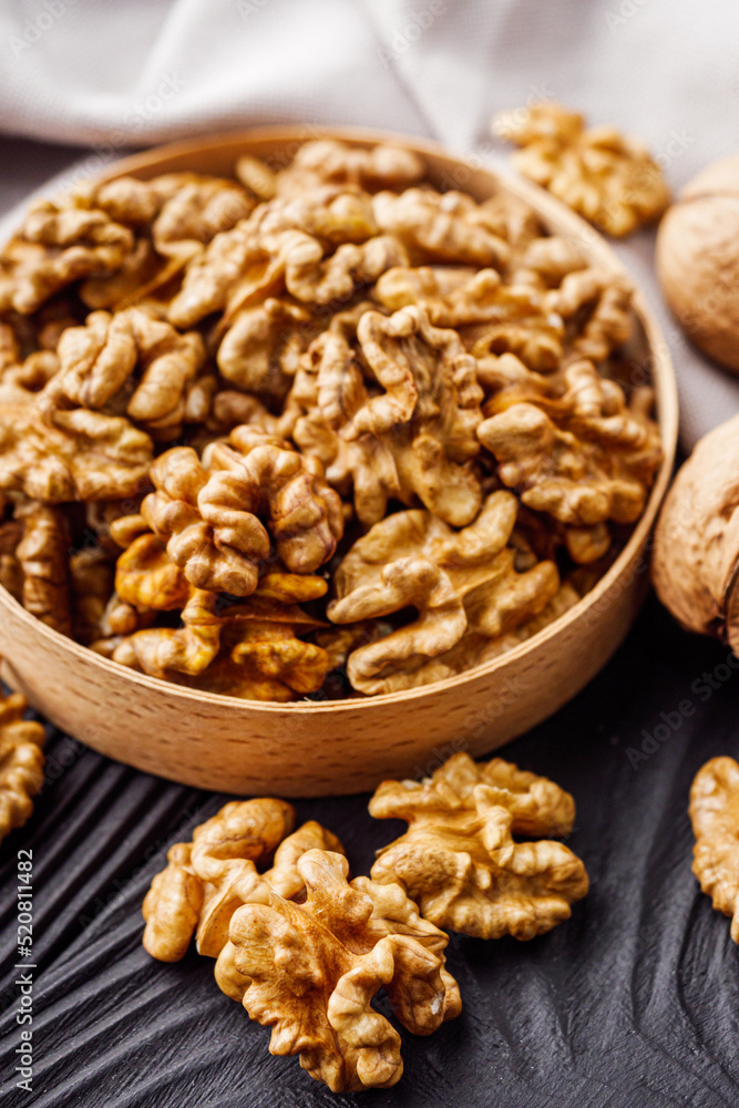 dried walnuts on a black rustic wooden background dried walnuts on a black rustic wooden background