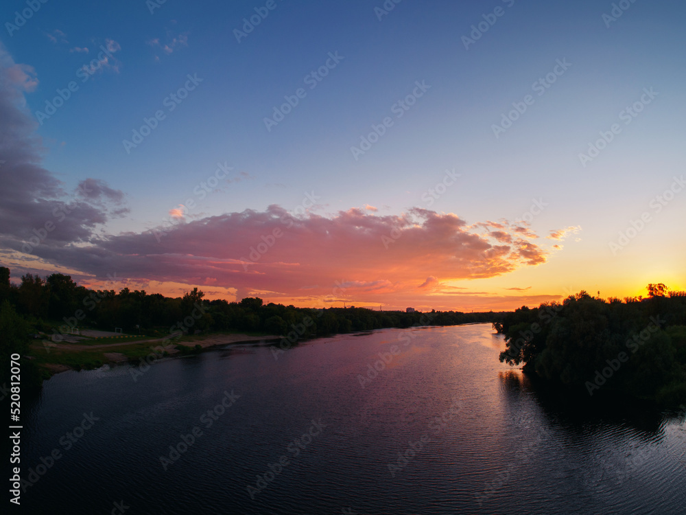 Bright cloudy sunset sky over the river