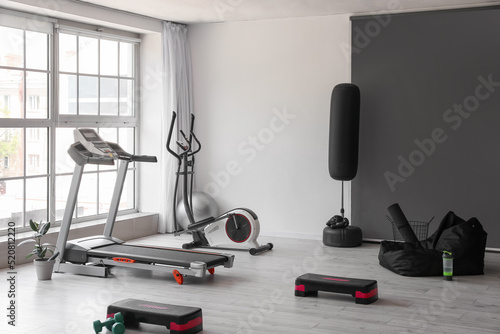 Interior of modern gym with treadmill and sport equipment