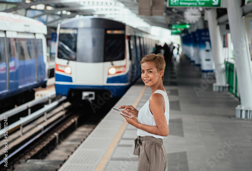 Happy Woman Using Digital Tablet While Standing At Railway Platform