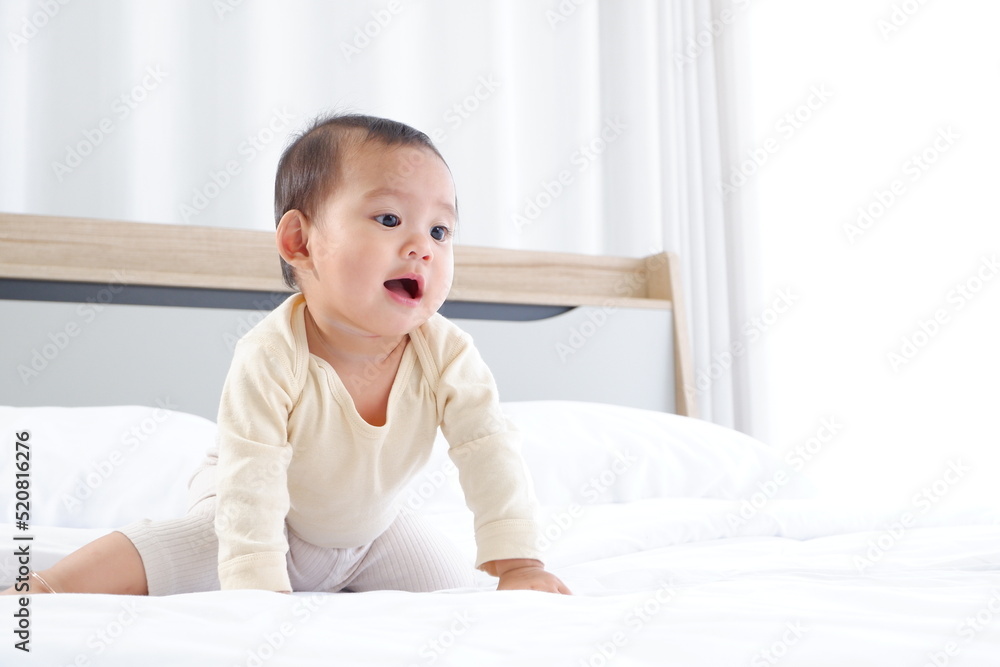 A cute little boy is sitting on a white mattress with a happy smile. A cute little boy is sitting on a white mattress with a happy smile.