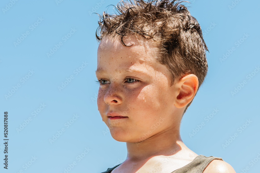 Sad boy standing on beach in summer Sad boy standing on beach in summer