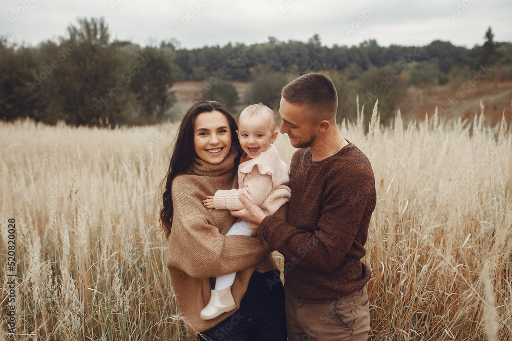 Cute and stylish family playing in a autumn field Cute and stylish family playing in a autumn field