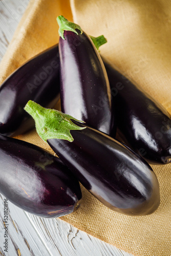 fresh natural eggplant on a light white wooden rustic background