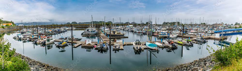 A panorama view of boats moored in the harbor in Sitka, Alaska in summertime