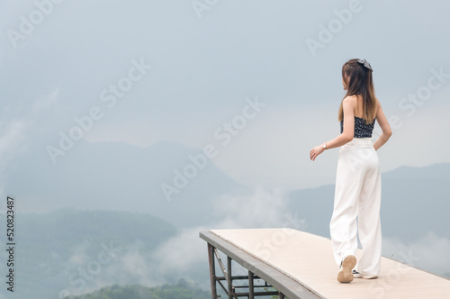Beautiful girl, sexy dress, relaxing at the high cliff, relaxing in nature. Holiday tourism.