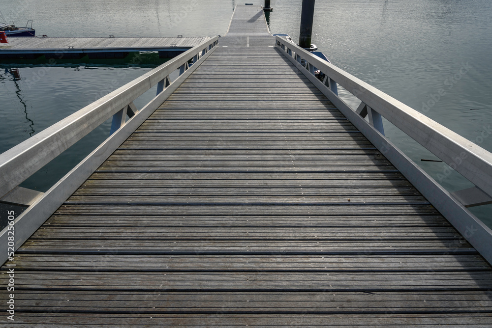 close-up of the descent to the pontoon of the Hendaye marina. Solitaire wood and aluminum railings. Completely calm sea.