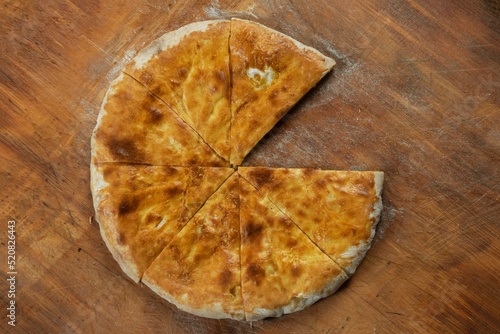 Baked homemade cheese pie on wooden background. Bulgarian banitsa, Georgian khachapuri, Greek tiropita