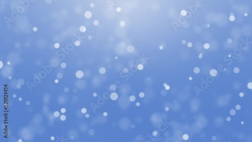 Animated festive light blue winter background with falling snowflake bokeh particles.
