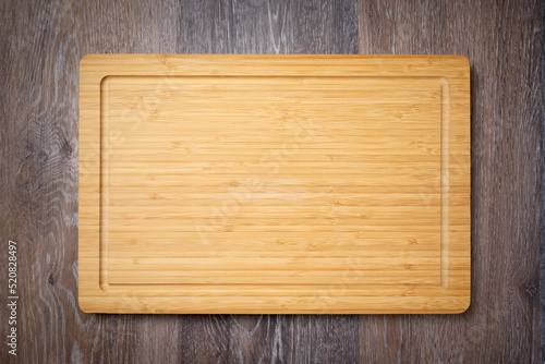 Wooden chopping board. Kitchen cutting board on wooden table, top view