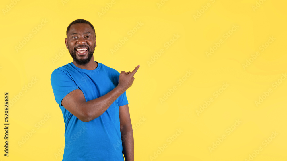 Happy Black Male Pointing Finger Aside On Yellow Background, Panorama Happy Black Male Pointing Finger Aside On Yellow Background, Panorama
